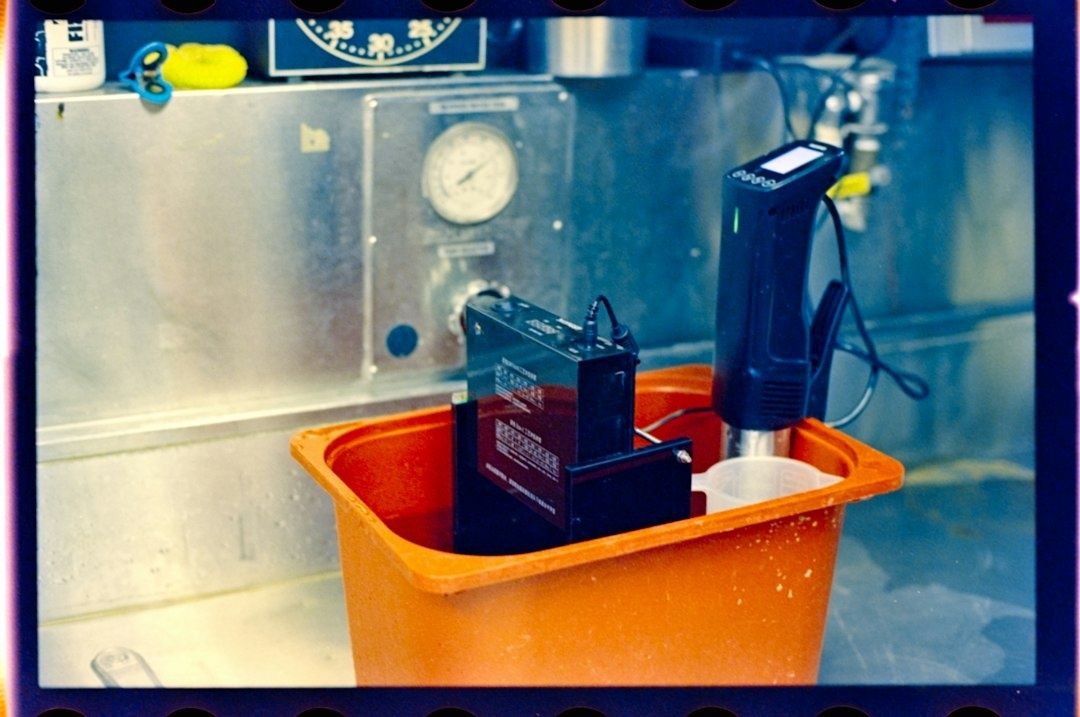 Sous vide-cirkulator och mätutrustning i ett orange vattenbad